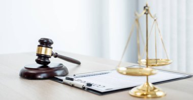Yargıcın hukuk bürosundaki tokmağında teraziler, adalet terazileri ve dava belgeleri var. Hukuk ve adalet kavramları.