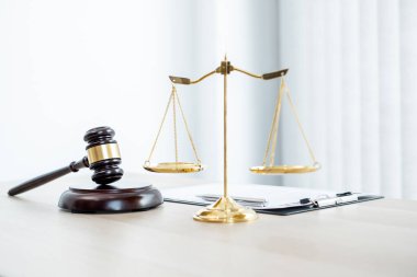 Yargıcın hukuk bürosundaki tokmağında teraziler, adalet terazileri ve dava belgeleri var. Hukuk ve adalet kavramları.