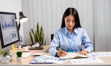 Asyalı kadınlar masalarında oturup yatırımlarıyla ilgili sonuçları gösteren mali grafikleri hesaplıyor ve başarılı bir iş büyüme süreci planlıyorlar..