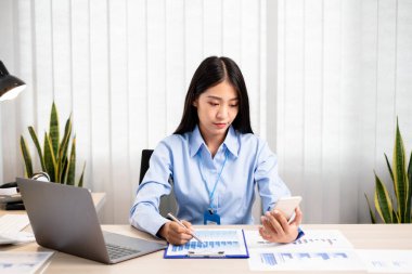 Asyalı kadınlar masalarında oturup yatırımlarıyla ilgili sonuçları gösteren mali grafikleri hesaplıyor ve başarılı bir iş büyüme süreci planlıyorlar..