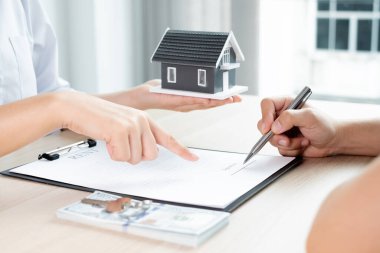 Kiralık evleri olan bir emlakçı ve müşteriler için ev kiralama sözleşmesi imzalayan bir emlakçı. Ev kiralama ve sigorta konsepti.