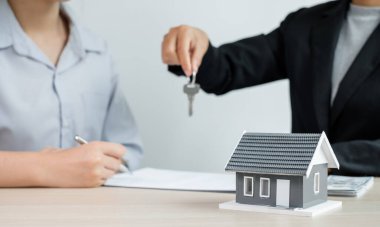 Emlak komisyoncusu imzayı attıktan sonra evin anahtarını ev kiralama ve ev sigortası konseptini satın alma anlaşmasına göre yeni sahibine teslim etti..