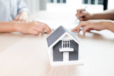 Kiralık evleri olan bir emlakçı ve müşteriler için ev kiralama sözleşmesi imzalayan bir emlakçı. Ev kiralama ve sigorta konsepti.