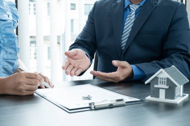 Ev modeli olan bir emlakçı müşterilerle ev kiralamak, ev sigortası yaptırmak ve resmi pazarlıklar tamamlandıktan sonra sözleşmeyi imzalamak hakkında konuşuyor..