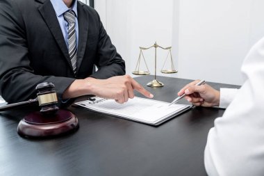 Bir erkek avukat ya da bir yargıç müvekkillerine yargı adaleti ve kovuşturma hakkında ölçekli danışmanlık yapıyor..