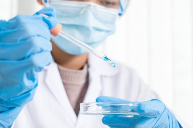 Tıp bilimcileri, bir kimya laboratuvarında virüsü analiz etmek için test camına yerleştirilmiş bir örnek yayınladılar. Bilimsel araştırma kavramları.