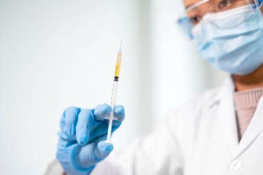 Profesyonel doktorlar aşı önleme ve viral enfeksiyonlardan korunmak için aşı örnekleri test edip analiz ederler. Tıbbi ve sağlık hizmetleri kavramları.