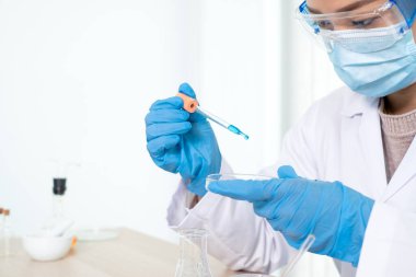 Tıp bilimcileri, bir kimya laboratuvarında virüsü analiz etmek için test camına yerleştirilmiş bir örnek yayınladılar. Bilimsel araştırma kavramları.