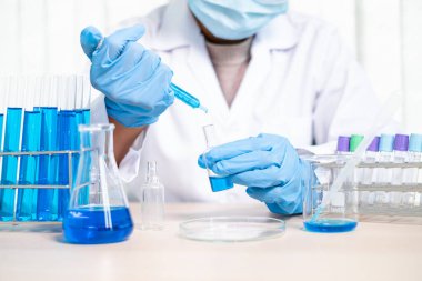 Tıp bilimcileri bir kimya laboratuvarında virüsü analiz etmek için deney şişesine yerleştirilmiş bir örnek bıraktılar. Bilimsel araştırma kavramları.