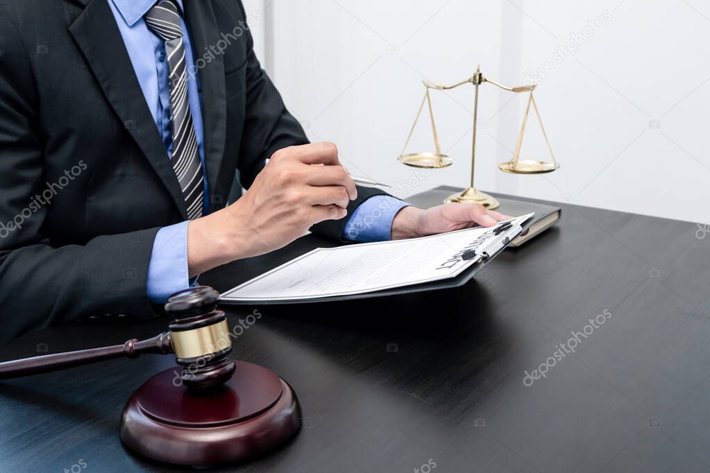 Professional male lawyers work at a law office There are scales, Scales of justice, judges gavel, and litigation documents. Concepts of law and justice.
