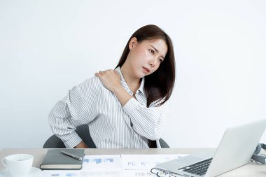 Asyalı kadınlar dizüstü bilgisayarla çalışmaktan yorulurlar. Bir koltuğa oturup dinlenirler ve ofiste sıkı çalışırlar..