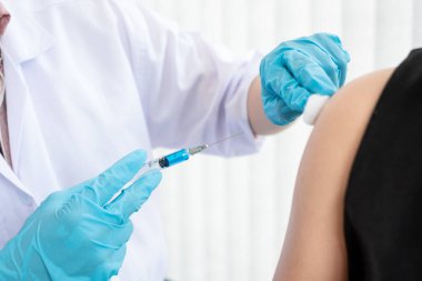 Erkek doktorlar hastanelerde, sağlık hizmetlerinde ve tıbbi konseptlerde salgın hastalıkları önlemek için şırıngalarla aşılandılar..