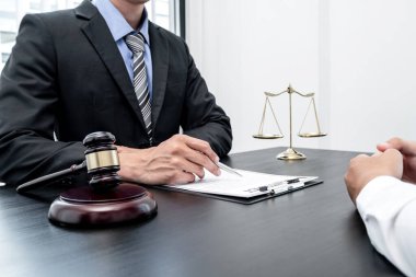Bir erkek avukat ya da bir yargıç müvekkillerine yargı adaleti ve kovuşturma hakkında ölçekli danışmanlık yapıyor..
