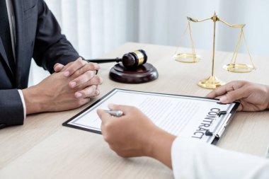 Bir erkek avukat ya da bir yargıç müvekkillerine yargı adaleti ve kovuşturma hakkında ölçekli danışmanlık yapıyor..