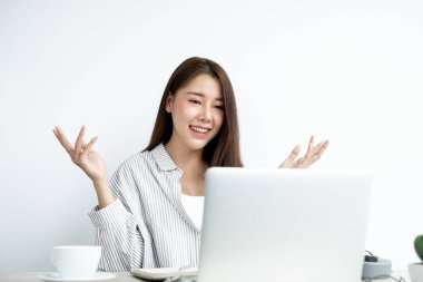 Video çağrısı, Asyalı genç bir kadın internet üzerinden uzun mesafeli video ile iletişim kuruyor, dijital laptop ekranına bakıyor, bir arkadaşıyla mutlu bir şekilde selamlaşıyor..