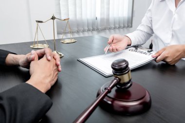 Bir erkek avukat ya da bir yargıç müvekkillerine yargı adaleti ve kovuşturma hakkında ölçekli danışmanlık yapıyor..