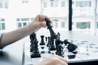 Satranç turnuvalarında satranç oynayan iş kadınlarının elleri liderlik, takipçiler ve stratejik planlar, iş başarısı oluşturma süreçleri ve takım çalışmalarını gösteriyor..