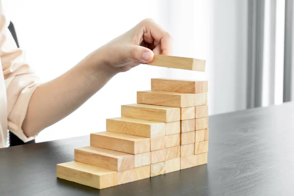 Ahşap blok oyunu oynayan iş kadınlarının elleri. Ticari büyüme ve başarı için yönetim riski ve strateji planlarını kabul et.