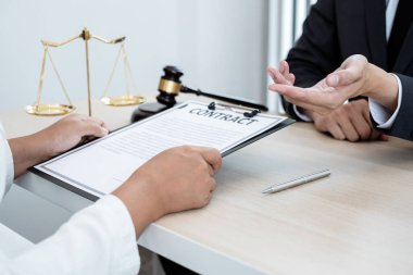 Bir erkek avukat ya da bir yargıç müvekkillerine yargı adaleti ve kovuşturma hakkında ölçekli danışmanlık yapıyor..