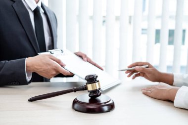 Bir erkek avukat ya da bir yargıç müvekkillerine yargı adaleti ve kovuşturma hakkında ölçekli danışmanlık yapıyor..