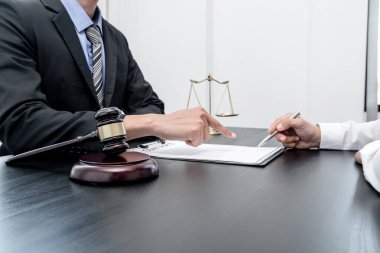 Bir erkek avukat ya da bir yargıç müvekkillerine yargı adaleti ve kovuşturma hakkında ölçekli danışmanlık yapıyor..