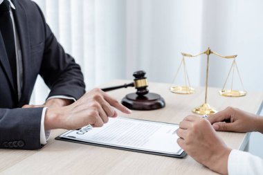 Bir erkek avukat ya da bir yargıç müvekkillerine yargı adaleti ve kovuşturma hakkında ölçekli danışmanlık yapıyor..