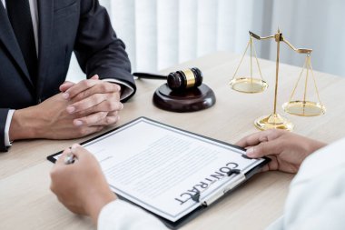 Bir erkek avukat ya da bir yargıç müvekkillerine yargı adaleti ve kovuşturma hakkında ölçekli danışmanlık yapıyor..