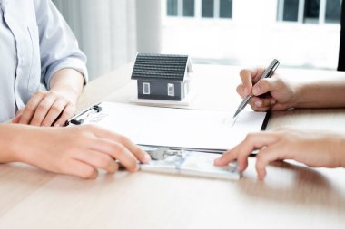 Kiralık evleri olan bir emlakçı ve müşteriler için ev kiralama sözleşmesi imzalayan bir emlakçı. Ev kiralama ve sigorta konsepti.