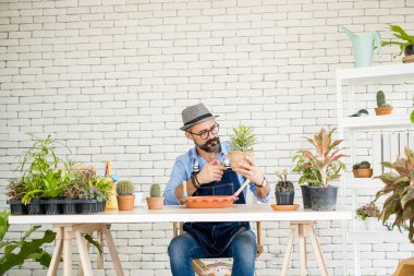 Yakışıklı gözlüklü ve sakallı yaşlı bir adam ağaçlarla ilgilenmekten zevk alır. Hobi olarak ağaçları budamaktan, bahçe işlerinden, mutlu bir emeklilik hayatından hoşlanır..
