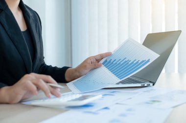 Muhasebeci bir kadının eli, ofisteki mali sonuçları analiz ediyor ve hesaplıyor..