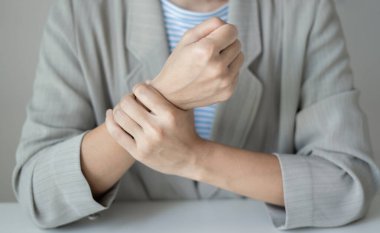 Bileğinde ağrı, avucunda uyuşukluk ve ağrı olan bir kadın elinin sinir uçlarında ağrı ve karıncalanma vardır. Bu ofiste uzun süre oturup çalışmanın bir yan etkisidir..