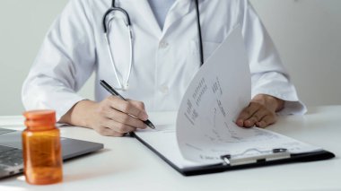 Kadın doktor oturdu ve hastanın geçmişini kontrol etti ve hasta bilgilerini kaydetmek için bir dizüstü bilgisayar kullandı. Tıbbi kavramlar ve ilgi alanları.