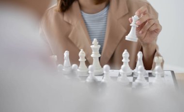 Satranç oynayan iş adamlarının eli liderlik, takipçiler ve ticari başarı stratejilerini gösteriyor.