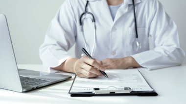 Kadın doktor oturdu ve hastanın geçmişini kontrol etti ve hasta bilgilerini kaydetmek için bir dizüstü bilgisayar kullandı. Tıbbi kavramlar ve ilgi alanları.