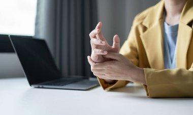 Bileğinde ağrı, avucunda uyuşukluk ve ağrı olan bir kadın elinin sinir uçlarında ağrı ve karıncalanma vardır. Bu ofiste uzun süre oturup çalışmanın bir yan etkisidir..