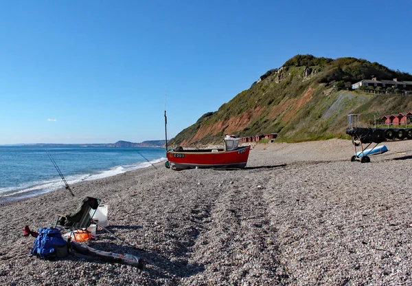 Un vieux bateau sur la plage de Branscombe dans le Devon, en Angleterre. L'équipement des pêcheurs est au premier plan . — Photo