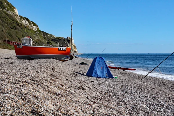 En gammal båt på stranden vid Branscombe i Devon, England. Yrkesfiskarnas utrustning står i förgrunden. — Stockfoto