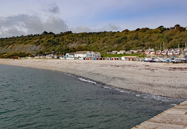 Pondok pantai di pantai shingle dilihat dari Cobb di Lyme Regis, Dorset, Inggris . — Stok Foto