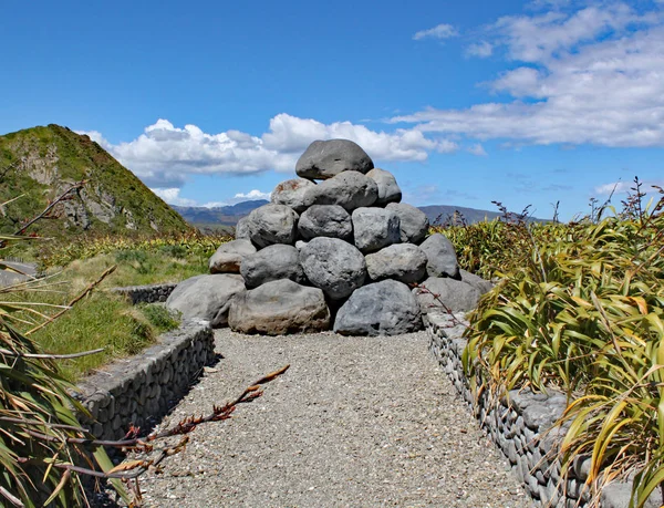 Tarakena 湾、北の島、ニュージーランドの近くの灰色の岩の山は、クック海峡にポンプで送られるために使用される生の下水タールポイントのリマインダーとして建てられました。それは今、ドゥー Doos の愛称で呼ばれています. — ストック写真