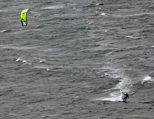 A kite surfer moves across Lyall Bay in Wellington New Zealand on a grey stormy day — Stock Photo, Image