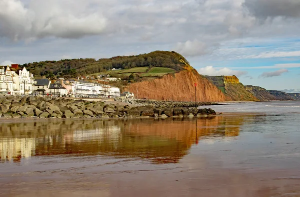 View of the eastern end of Sidmouth Esplanade and sandstone cliff. This cliff has regular rockfalls which reduce the lengths of the gardens on top. Royalty Free Stock Photos