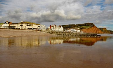 Sidmouth Esplanade ve kumtaşı uçurumun doğu ucunda görünümü. Bu uçurumun üstünde bahçelerin uzunluklarını azaltmak düzenli kayalıklar vardır.