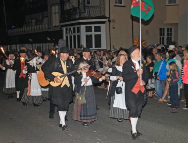 Sidmouth, Devon, İngiltere - 10 Ağustos 2012: Gallerli bir grup sanatçı halk haftasının gece kapanış alayı içinde yer alıyor