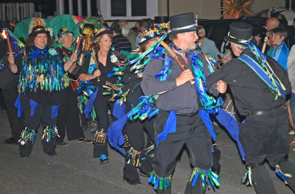 Sidmouth, Devon, England-10 augusti 2012: en grupp av Morris dansare klädd i dekorerade topp hattar och trasiga blå västar delta i nattetid stängning procession av folk vecka — Stockfoto