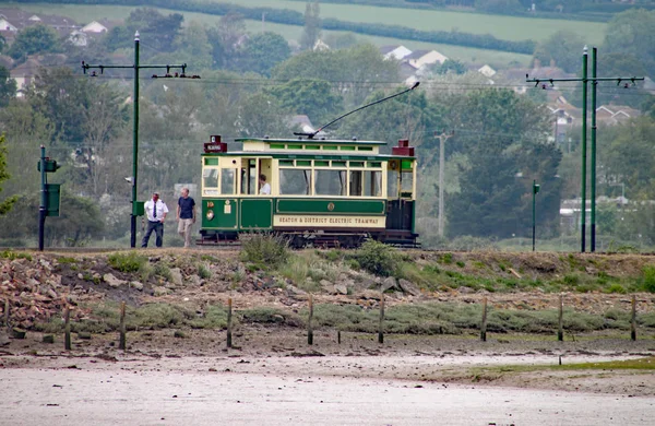 SEATON, DEVON, ENGLAND - MAY 22ND 2012: Two men get out of a green tram to inspect a box fixed to post — Stock Photo, Image