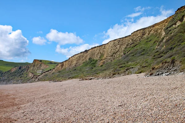 La plage de galets à Eype dans le Dorset par une journée ensoleillée, Les falaises de grès de la côte jurassique peuvent être vus en arrière-plan — Photo