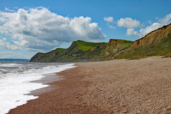 La plage de galets à Eype dans le Dorset par une journée ensoleillée, Les falaises de grès de la côte jurassique peuvent être vus en arrière-plan — Photo