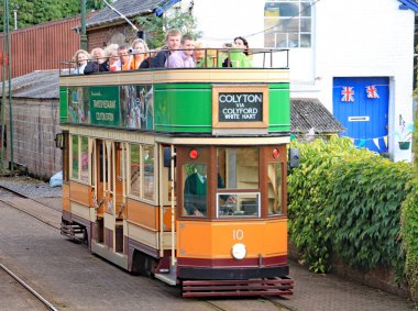 Colyton, Devon, İngiltere - 6 Ağustos 2012: Turuncu ve yeşil bir tramvay Seaton tramvay üzerinde Colyford istasyonuna çeker. Yolcular özel bir etkinlik için geliyor.