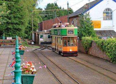 Colyton, Devon, İngiltere - 6 Ağustos 2012: Turuncu ve yeşil bir tramvay Seaton tramvay üzerinde Colyford istasyonuna çeker. Yolcular özel bir etkinlik için geliyor.