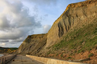 Dorset, İngiltere'deki West Bay'deki kumtaşı kayalıklar. Bu, Devon'daki Exmouth'tan Dorset'teki Studland Körfezi'ne kadar uzanan Jurassic sahilinin bir parçasıdır.